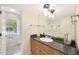 A vanity with a dark countertop and a large mirror offers a view into the shower at 6525 N 3Rd St, Phoenix, AZ 85012