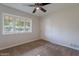 A neutral bedroom features a ceiling fan, a window, and a closet with sliding doors at 6525 N 3Rd St, Phoenix, AZ 85012