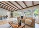 Stylish living room with wood beam ceilings, hardwood floors, and a seamless transition to the outdoors at 6525 N 3Rd St, Phoenix, AZ 85012