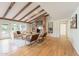 Spacious living room showcasing wood beam ceilings, a brick fireplace, and an open layout at 6525 N 3Rd St, Phoenix, AZ 85012
