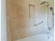 A neutral tiled shower has a bathtub, a shower niche, and safety bars at 6525 N 3Rd St, Phoenix, AZ 85012