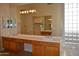 Bathroom featuring dual sinks, vanity area, a large mirror, and a walk-in closet at 7979 E Princess Dr # 8, Scottsdale, AZ 85255