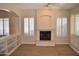 Cozy living room features a fireplace, built-in shelves, and plantation shutters at 7979 E Princess Dr # 8, Scottsdale, AZ 85255