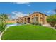 Expansive backyard with a large grassy area, swimming pool, and covered patio perfect for entertaining at 8298 E Tailfeather Dr, Scottsdale, AZ 85255