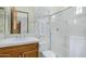 Bathroom showcasing white and gold wallpaper with wooden cabinets and shower with glass doors at 8298 E Tailfeather Dr, Scottsdale, AZ 85255