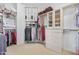 Walk-in closet with hanging rods, shelving, drawers, and glass front cabinets at 8298 E Tailfeather Dr, Scottsdale, AZ 85255