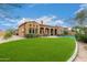 Stunning backyard view of a home with a covered patio, pool, and expansive lawn at 8298 E Tailfeather Dr, Scottsdale, AZ 85255