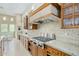 Well-equipped kitchen featuring granite countertops, wood cabinetry, and a modern gas range at 8298 E Tailfeather Dr, Scottsdale, AZ 85255