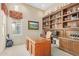 Well-lit home office with custom wood built-ins, desk, shelving, and trophy display space at 8298 E Tailfeather Dr, Scottsdale, AZ 85255