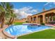 Lush backyard featuring a sparkling pool with spa, outdoor kitchen and a covered patio at 8298 E Tailfeather Dr, Scottsdale, AZ 85255