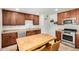 Kitchen featuring wooden cabinets, stainless steel appliances, a butcher block island, and tile floors at 844 E Ruth Ave, Phoenix, AZ 85020
