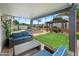 Backyard patio with seating, a pool and spa, and a green lawn at 8776 E Brilliant Sky Cir, Gold Canyon, AZ 85118