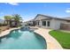 Inviting backyard featuring a sparkling pool with an attached spa, palm tree, and landscaped patio at 8776 E Brilliant Sky Cir, Gold Canyon, AZ 85118