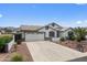 Front exterior featuring desert landscaping, and a long concrete driveway leading to a two-car garage at 8776 E Brilliant Sky Cir, Gold Canyon, AZ 85118
