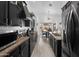 Galley kitchen showcasing stainless steel appliances, dark wood cabinets, and modern lighting at 8776 E Brilliant Sky Cir, Gold Canyon, AZ 85118