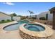 Beautiful pool and spa featuring stone accents, waterfall feature and rock landscaping at 8776 E Brilliant Sky Cir, Gold Canyon, AZ 85118