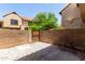 Private backyard featuring decorative gravel, concrete patio, and a wooden gate in a tan brick surround at 921 W University Dr # 1232, Mesa, AZ 85201