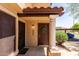 Inviting townhome entrance featuring desert landscaping, a welcoming wreath, and a secure screen door at 921 W University Dr # 1232, Mesa, AZ 85201