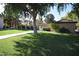 Lush green lawn and mature trees with a walking path leading to a private entrance at 921 W University Dr # 1232, Mesa, AZ 85201