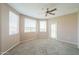 Spacious living room with large windows, neutral carpet, and a ceiling fan at 9820 N Central Ave # 212, Phoenix, AZ 85020