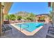 Community pool surrounded by lush landscaping and comfortable lounge seating under a clear blue sky at 9820 N Central Ave # 212, Phoenix, AZ 85020
