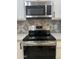 Stainless steel stove and microwave set against a backdrop of white cabinets and patterned backsplash at 1010 W 13Th St, Tempe, AZ 85281