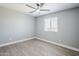 Bright bedroom with gray walls, wood-look flooring, and a ceiling fan and a large window at 11012 E Elton Ave, Mesa, AZ 85208