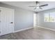 Bedroom featuring gray walls, wood-look flooring, a ceiling fan, and a bright window at 11012 E Elton Ave, Mesa, AZ 85208