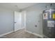 Spacious utility room with water heater, white trim, grey walls, and updated flooring at 11012 E Elton Ave, Mesa, AZ 85208