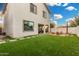 Spacious backyard with artificial turf, a fire pit, and wood chairs at 11541 E Corbin Ave, Mesa, AZ 85212