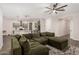 Comfortable living room featuring a ceiling fan, carpet, and a spacious green couch at 11541 E Corbin Ave, Mesa, AZ 85212