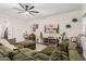 Spacious living room featuring a ceiling fan, carpet, a sectional couch, decorative artwork and plants at 11541 E Corbin Ave, Mesa, AZ 85212
