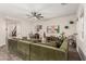 Spacious living room featuring a ceiling fan, carpet, and a large sectional couch with decorative artwork and plants at 11541 E Corbin Ave, Mesa, AZ 85212