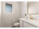 Modern powder room with white vanity, gold fixtures, and ample natural light at 11541 E Corbin Ave, Mesa, AZ 85212