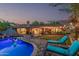 Backyard oasis with heated pool, lounge chairs, patio seating and string lights at 11822 S Coconino St, Phoenix, AZ 85044