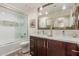 Well-lit bathroom featuring a double vanity, updated fixtures, and glass-enclosed shower at 11822 S Coconino St, Phoenix, AZ 85044
