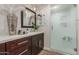 Modern bathroom featuring dark wood cabinetry, quartz counters, decorative lighting and glass-enclosed shower at 11822 S Coconino St, Phoenix, AZ 85044