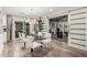Modern dining room with a glass table, white chairs, a stylish light fixture, and a sliding barn door at 11822 S Coconino St, Phoenix, AZ 85044