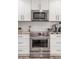 Close-up of the kitchen featuring a stainless steel oven and microwave, and white cabinets at 11822 S Coconino St, Phoenix, AZ 85044