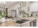Close-up of a kitchen island featuring a stainless steel sink, granite countertops, and ample cabinet space at 11822 S Coconino St, Phoenix, AZ 85044