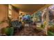 Covered patio with cozy seating, lush plants, and a paver floor, ideal for outdoor relaxation at 11822 S Coconino St, Phoenix, AZ 85044