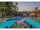 Backyard pool featuring lounge chairs and a meticulously maintained yard at 11822 S Coconino St, Phoenix, AZ 85044