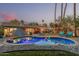 Backyard pool at dusk, featuring lounge chairs and a meticulously maintained yard at 11822 S Coconino St, Phoenix, AZ 85044