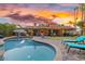 Outdoor pool and patio at dusk, featuring lounge chairs and a meticulously maintained yard at 11822 S Coconino St, Phoenix, AZ 85044