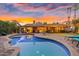 Backyard pool and patio at dusk, featuring lounge chairs and a meticulously maintained yard at 11822 S Coconino St, Phoenix, AZ 85044