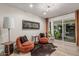 Cozy sitting area with comfortable orange chairs, modern lighting, and a view to the backyard at 11822 S Coconino St, Phoenix, AZ 85044