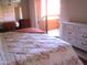 Cozy bedroom with a floral comforter, a white dresser, and access to a private balcony at 12222 N Paradise Village S Pkwy # 325, Phoenix, AZ 85032
