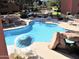 Community pool featuring comfortable seating, a rock grotto, and manicured landscaping at 12222 N Paradise Village S Pkwy # 325, Phoenix, AZ 85032