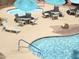 A view of a sparkling pool with tables and lounge chairs with blue umbrellas for shade at 12222 N Paradise Village S Pkwy # 325, Phoenix, AZ 85032