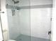 Modern shower with glass enclosure, white tile, and a mosaic floor at 12222 N Paradise Village S Pkwy # 325, Phoenix, AZ 85032